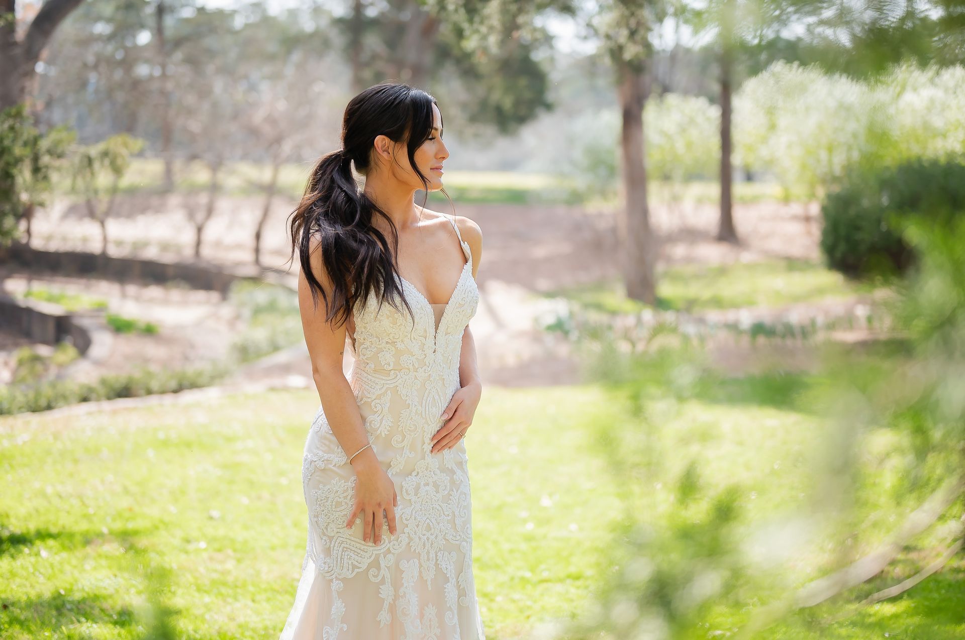 A woman in a wedding dress is standing in a field.