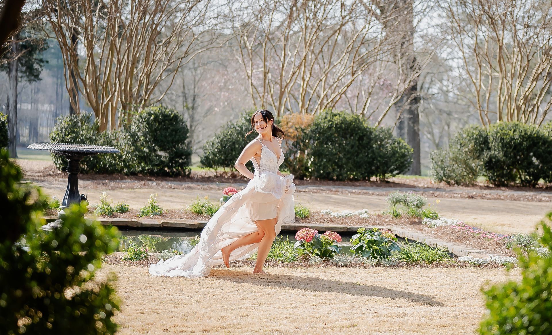 A woman in a white dress is running in a park.