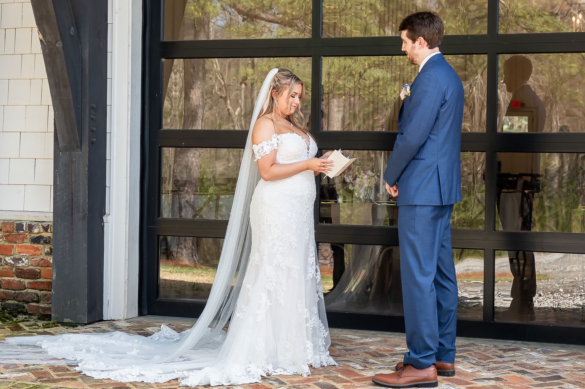 A bride and groom are standing next to each other reading their wedding vows.