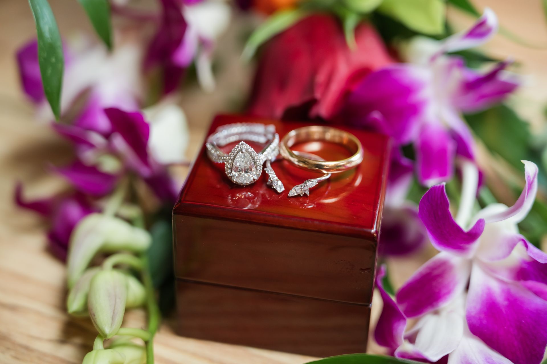 A close up of a lip balm on a table surrounded by black rocks.