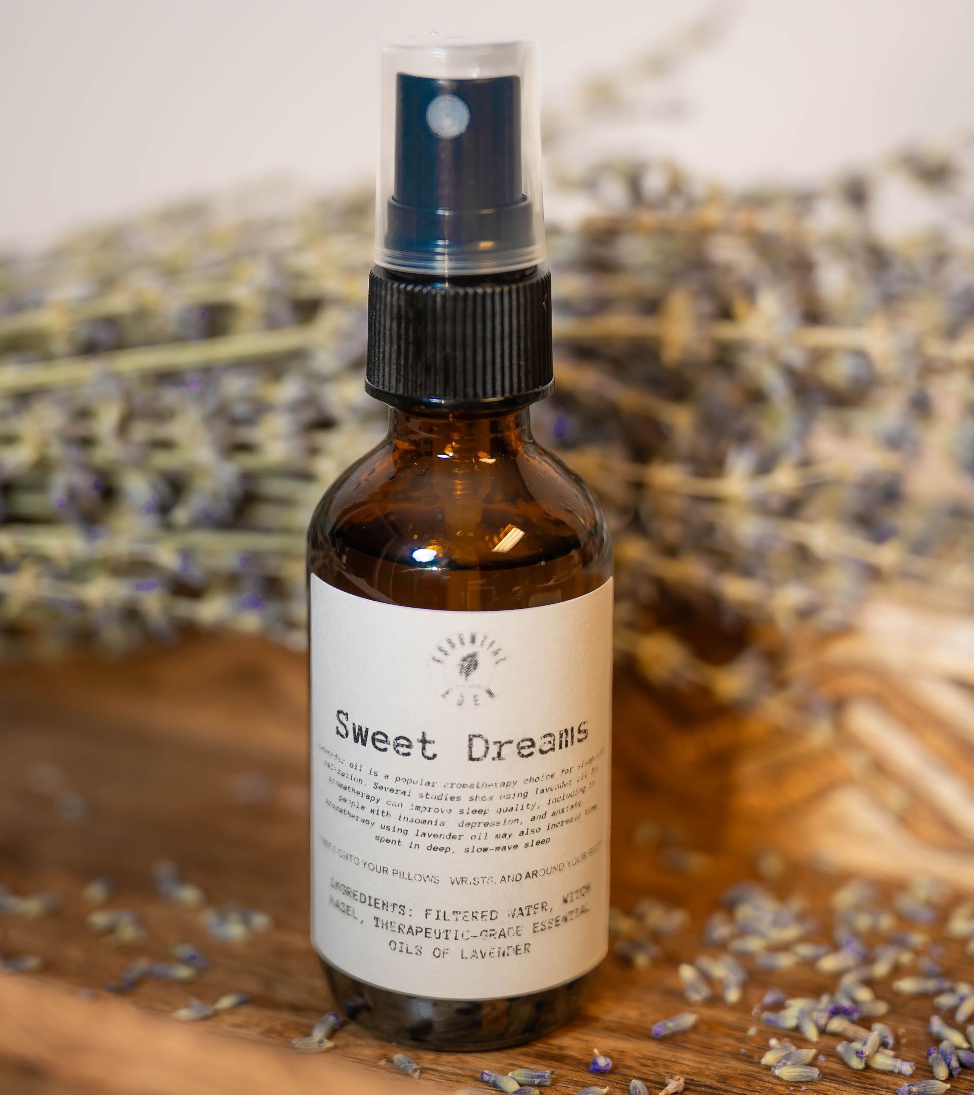 A bottle of sweet dreams spray is sitting on a wooden table.