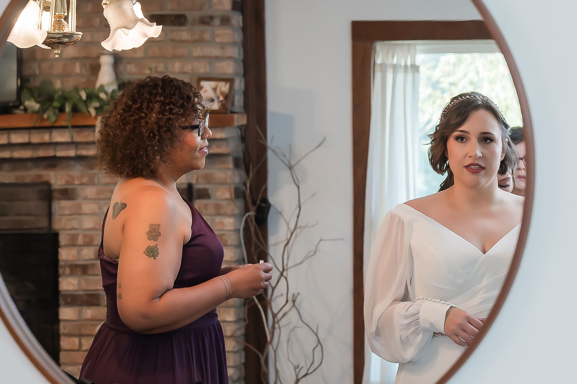 A woman in a purple dress is looking at herself in a mirror.