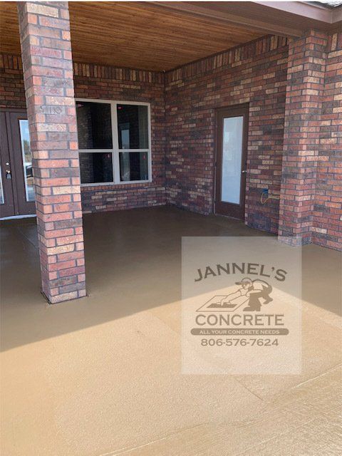 A patio with a brick wall and a sign that says jannel 's concrete