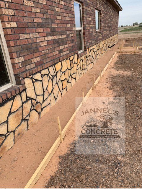 A brick house with a concrete walkway in front of it