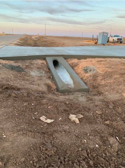 A concrete walkway with a pipe in the middle of it.