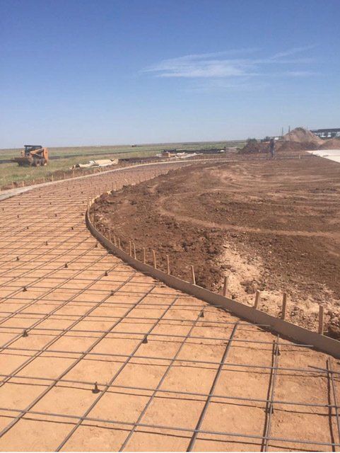 A dirt road is being built in the middle of a field.