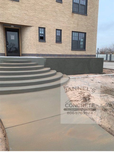 A brick building with stairs and a sign that says jannel 's concrete
