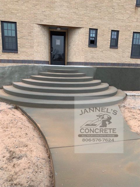 A jannel 's concrete logo is on the sidewalk in front of a building