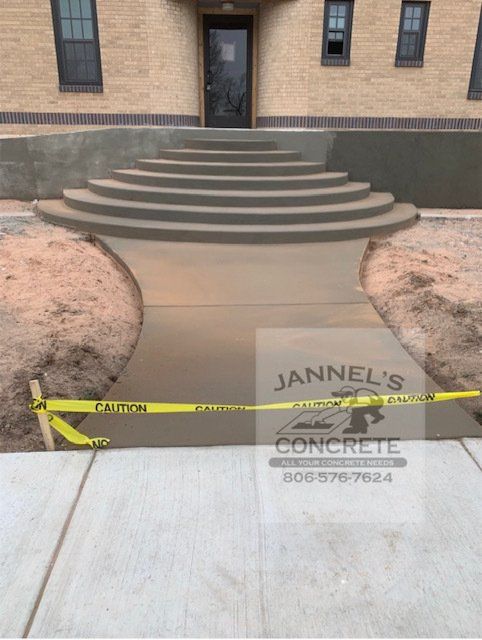 A jannel 's concrete sign is on the sidewalk in front of a building