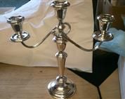 a silver candelabra is sitting on a wooden table .