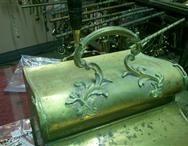 a brass bucket with a handle is sitting on top of a table .