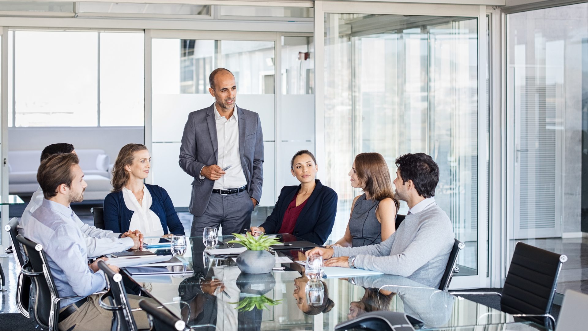 A group of business people are sitting around a conference table having a meeting.
