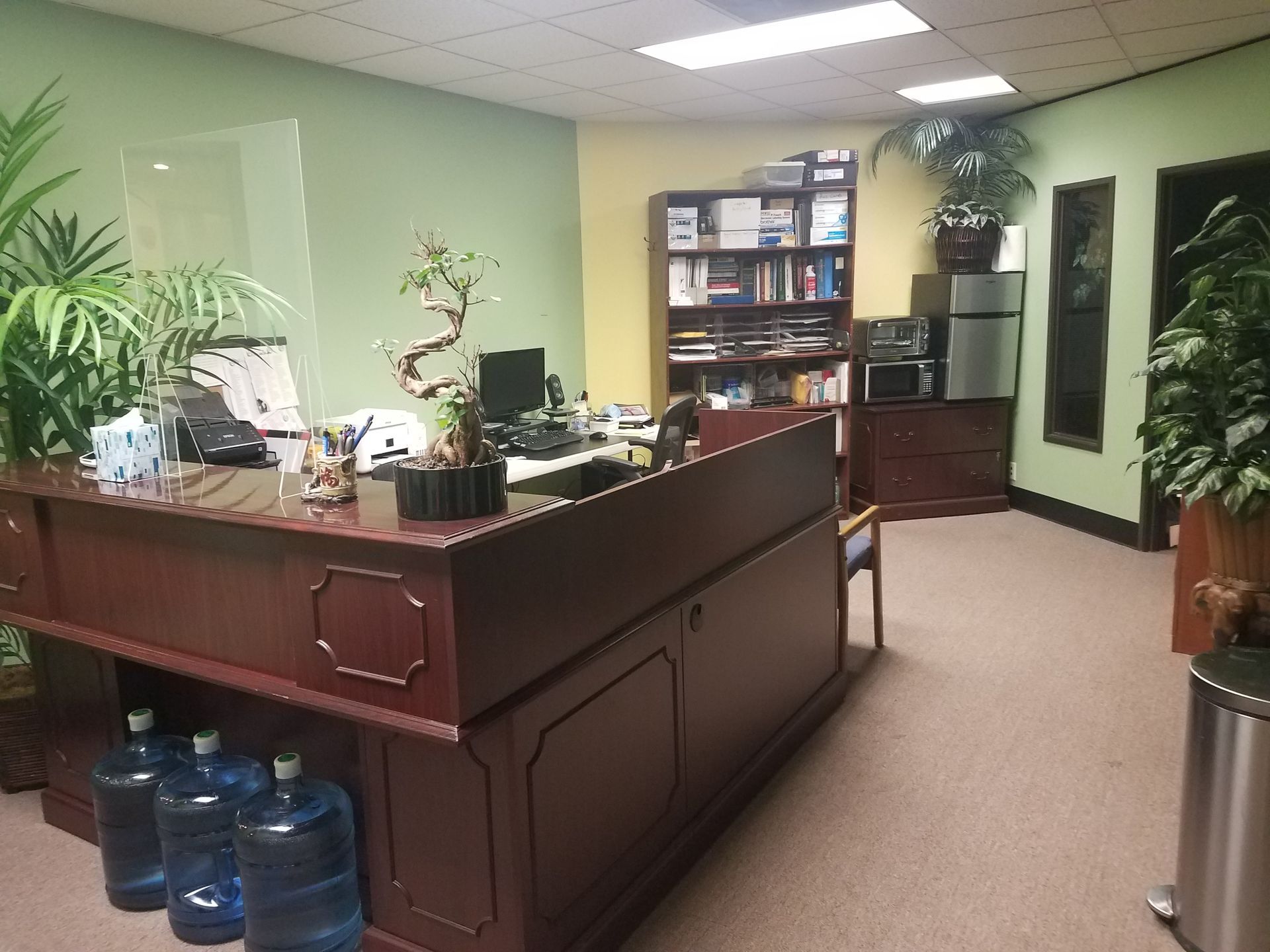 A reception area in an office with a desk and water bottles