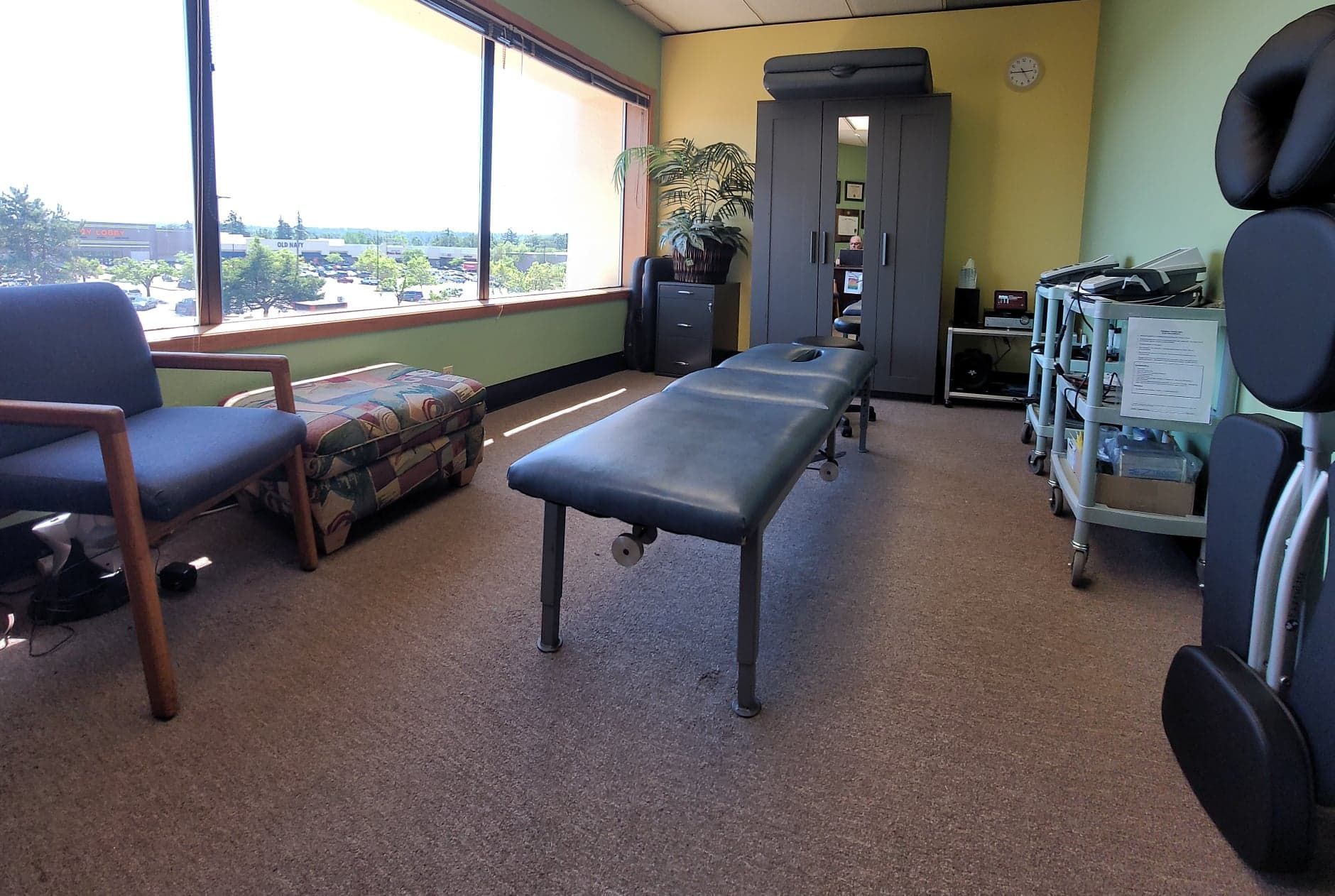 A waiting room with chairs and tables and a large window