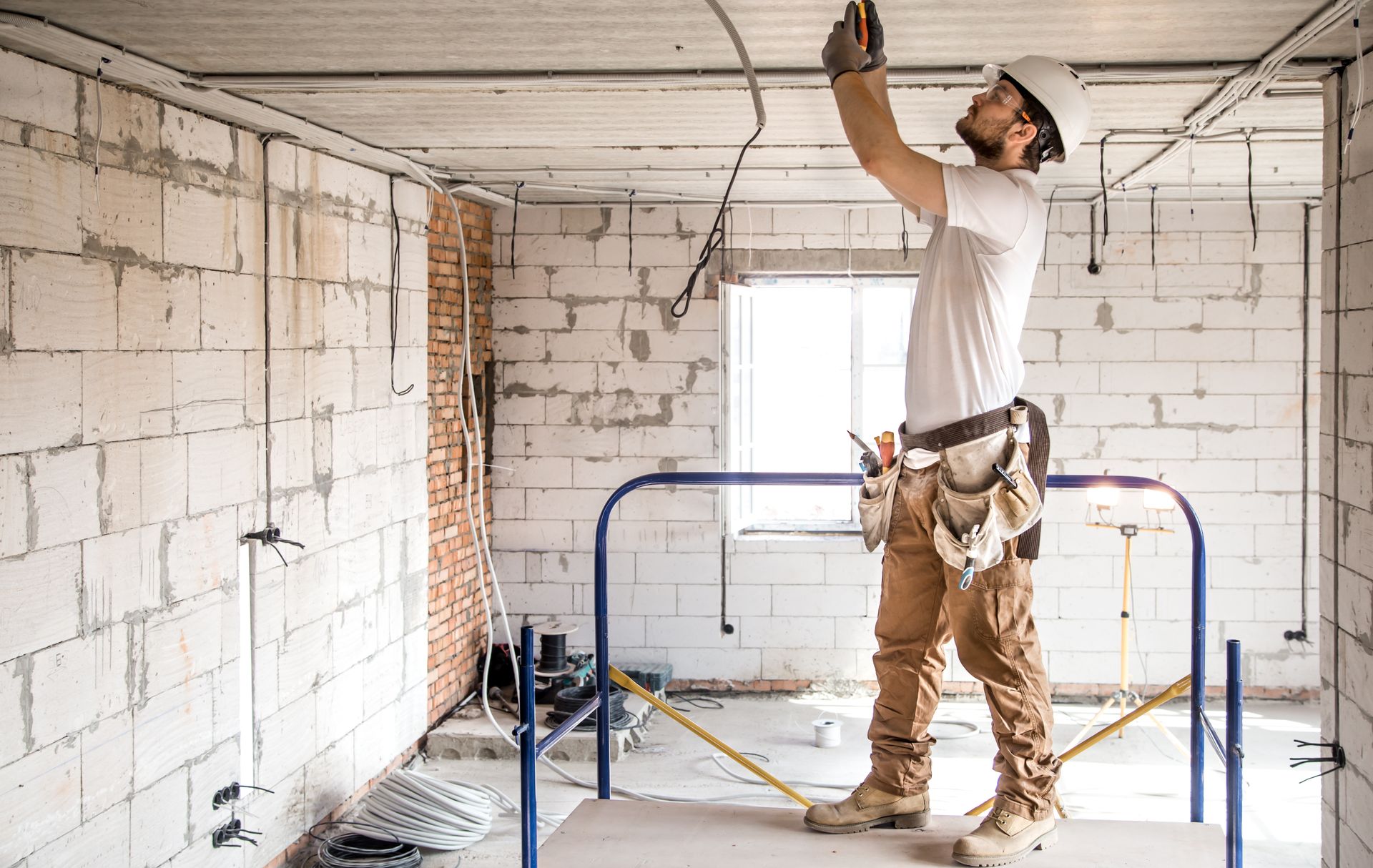 Electrician working with cables on the construction site