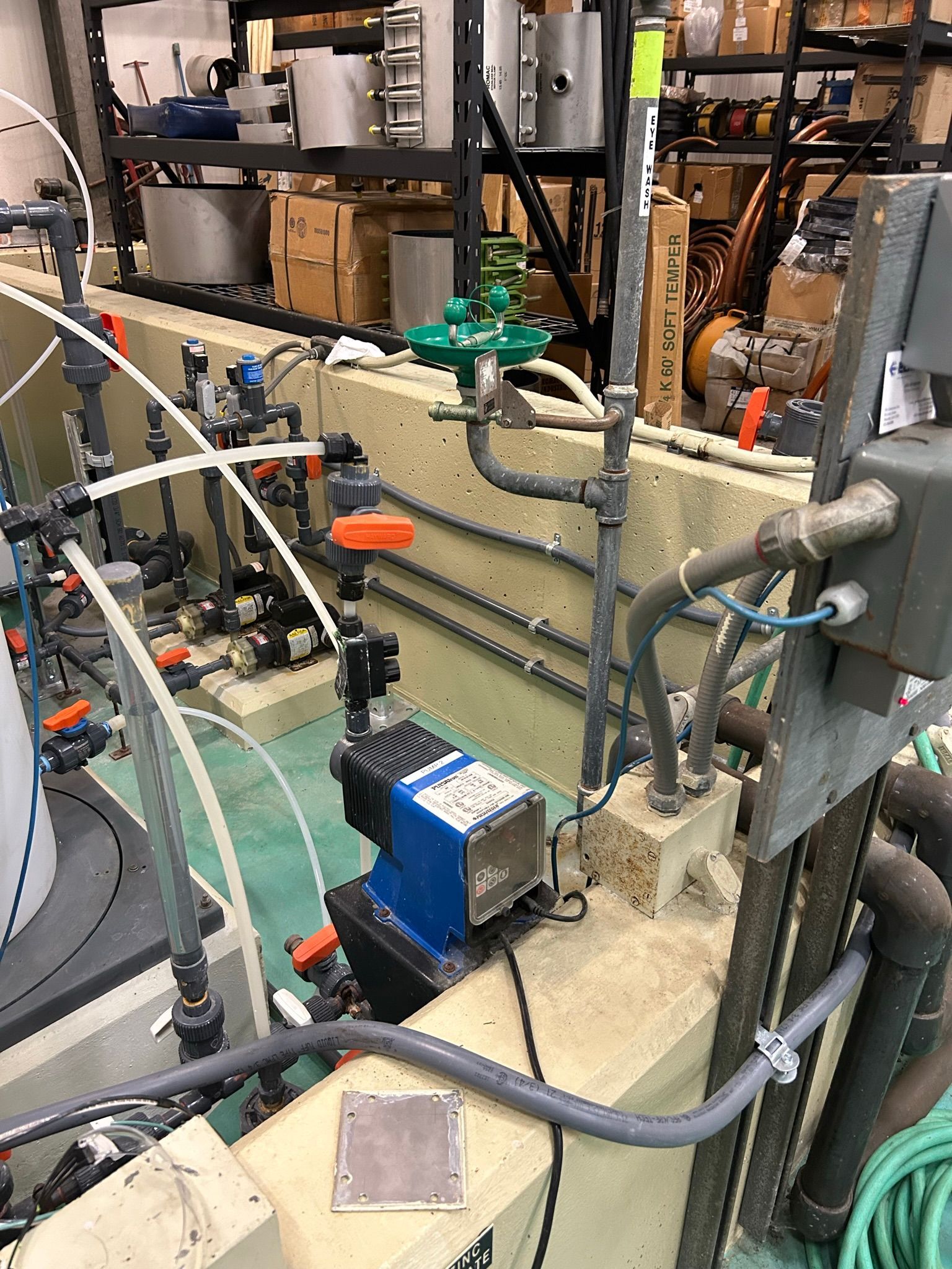 Industrial equipment with pipes, valves, and a pump; various colors in an industrial setting.