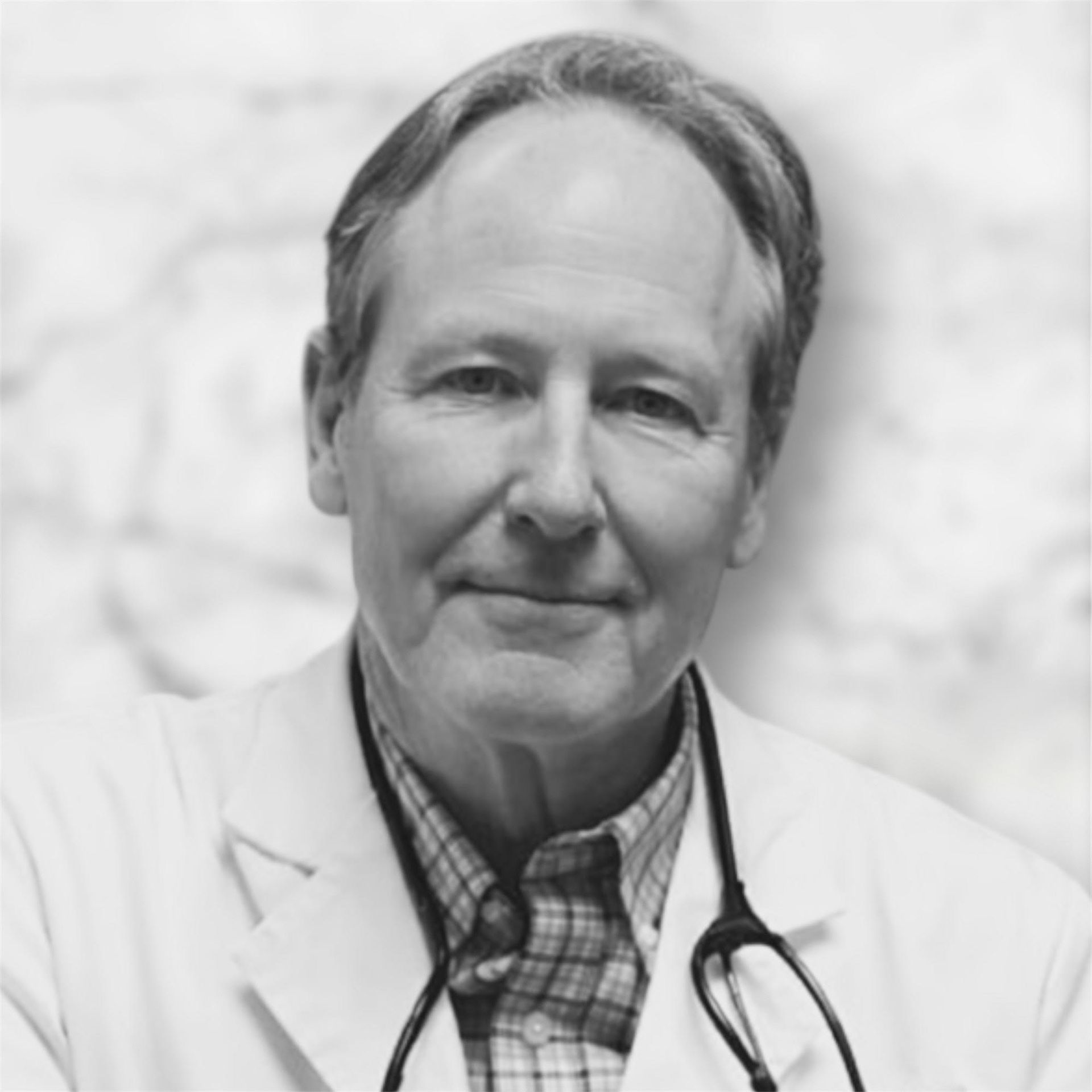 Man in a white coat with a stethoscope around his neck, smiling.