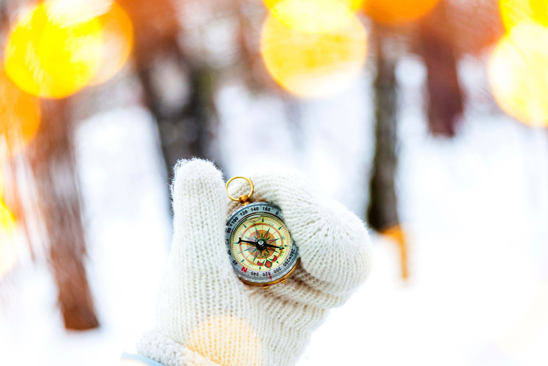 girl smiling in the snow while pulling her beanie