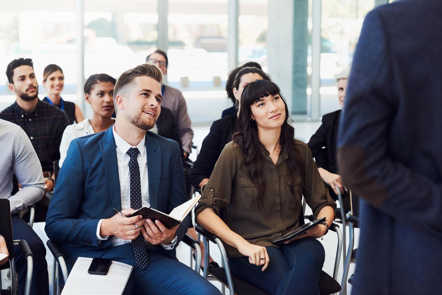 A group of people are sitting in chairs listening to a presentation.
