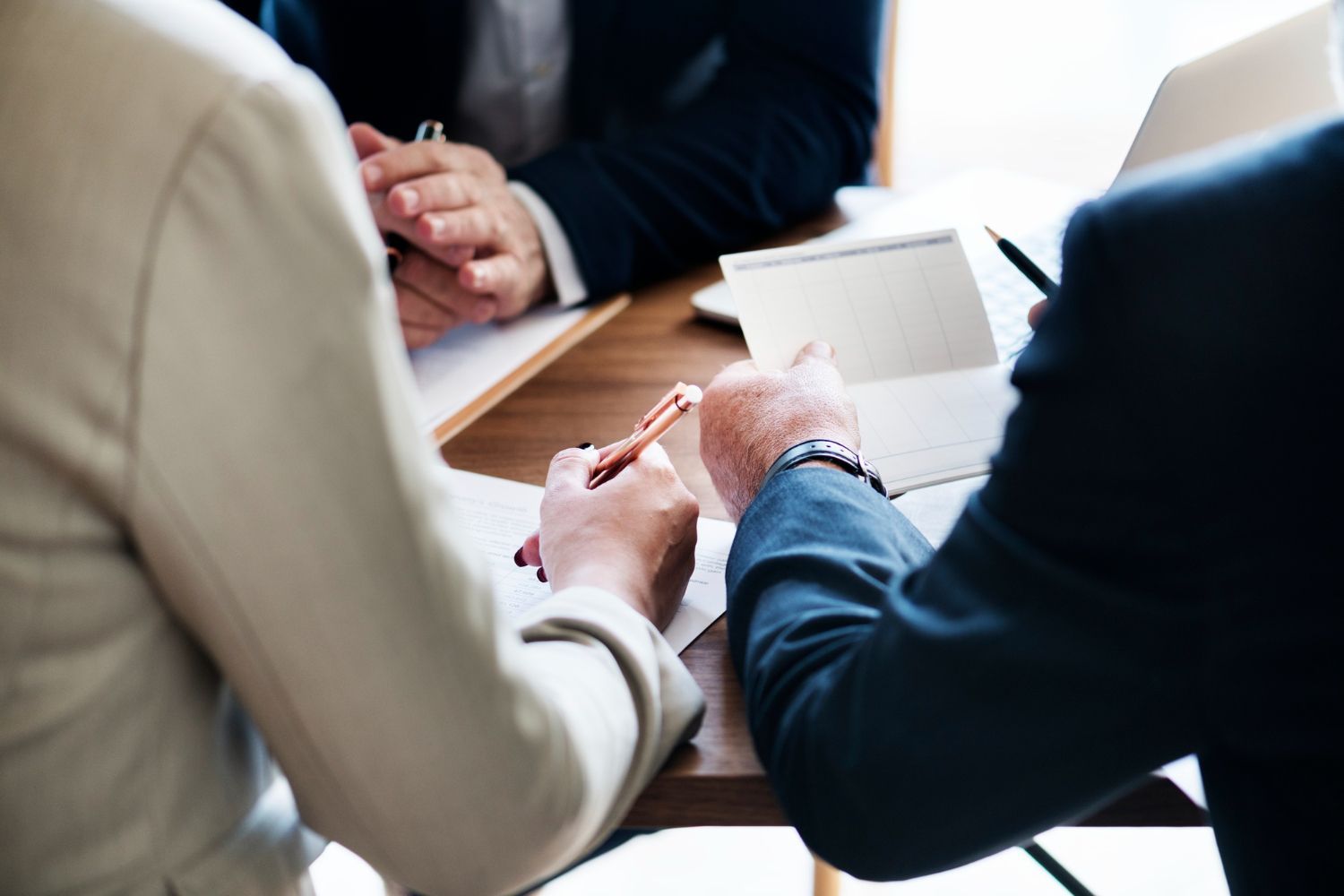 A group of people are sitting at a table having a meeting.
