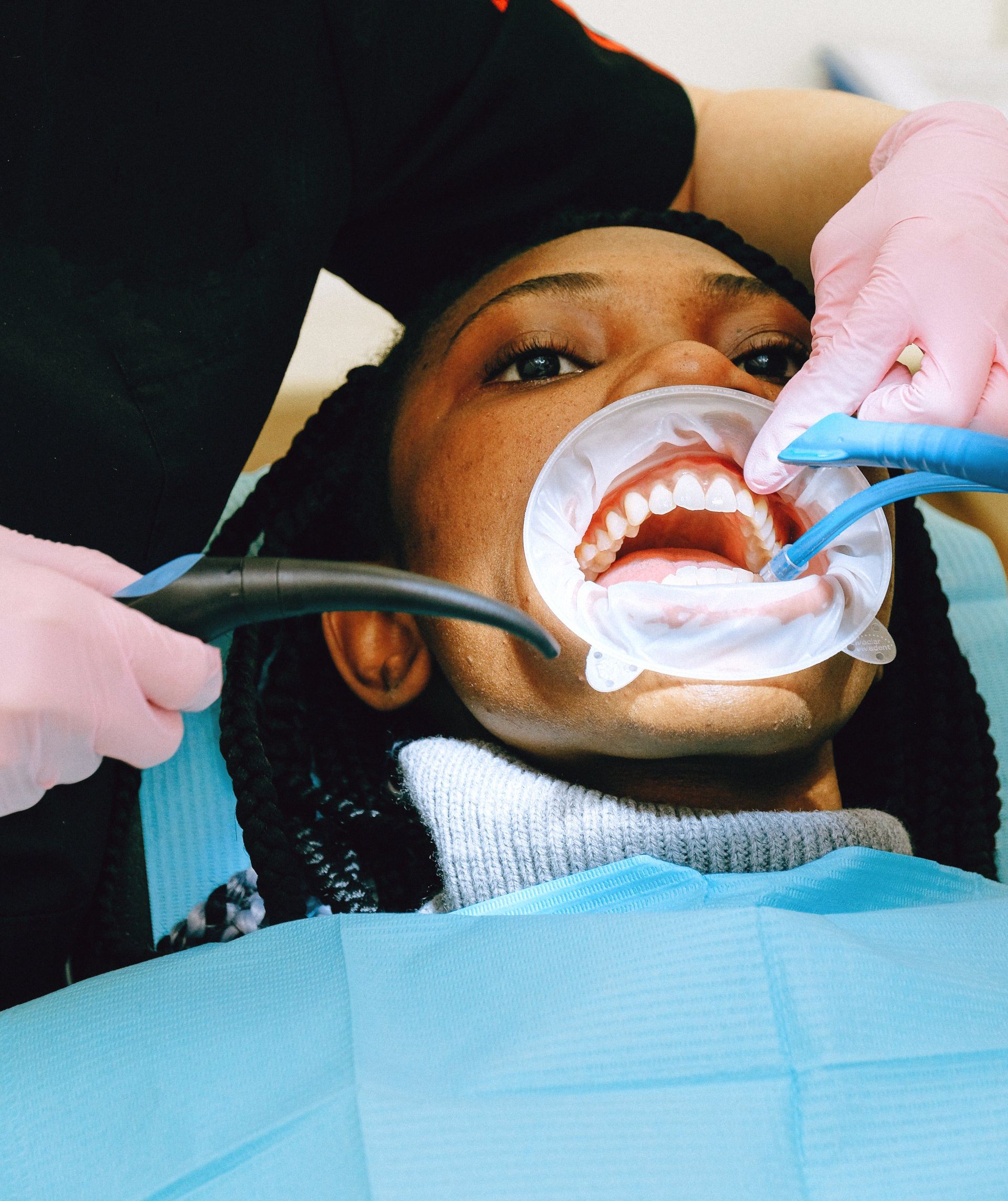 A woman is getting her teeth examined by a dentist