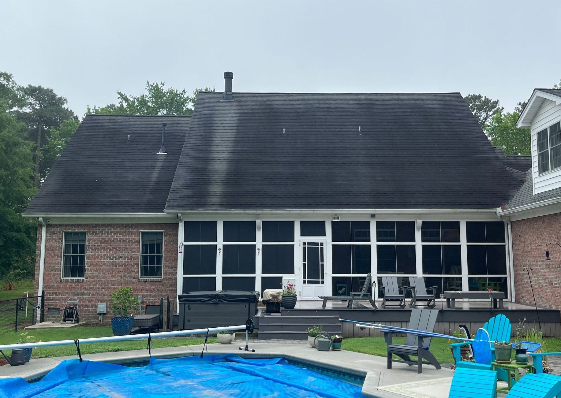 A large brick house with a screened in porch and patio.