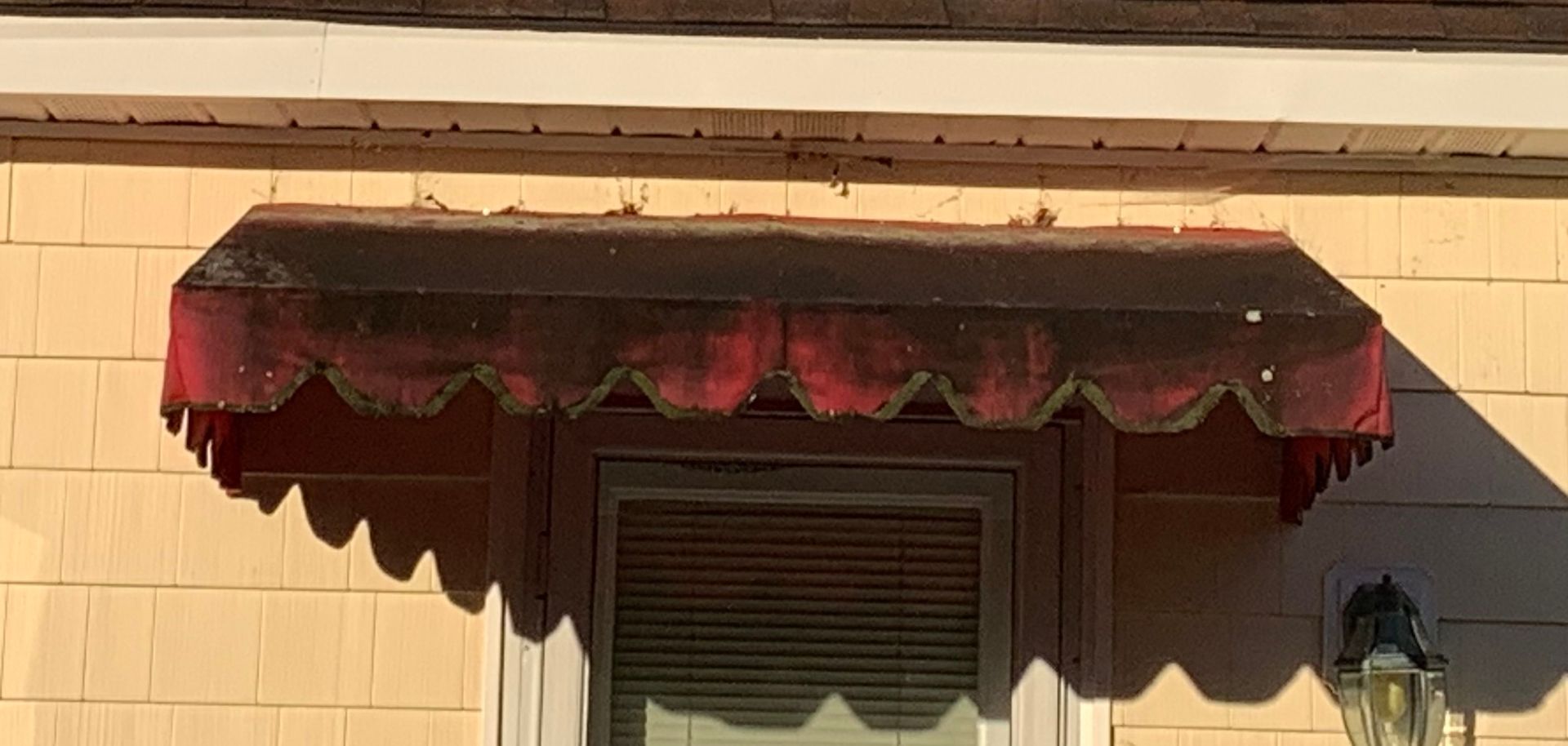 A blue awning over a door on a brick building