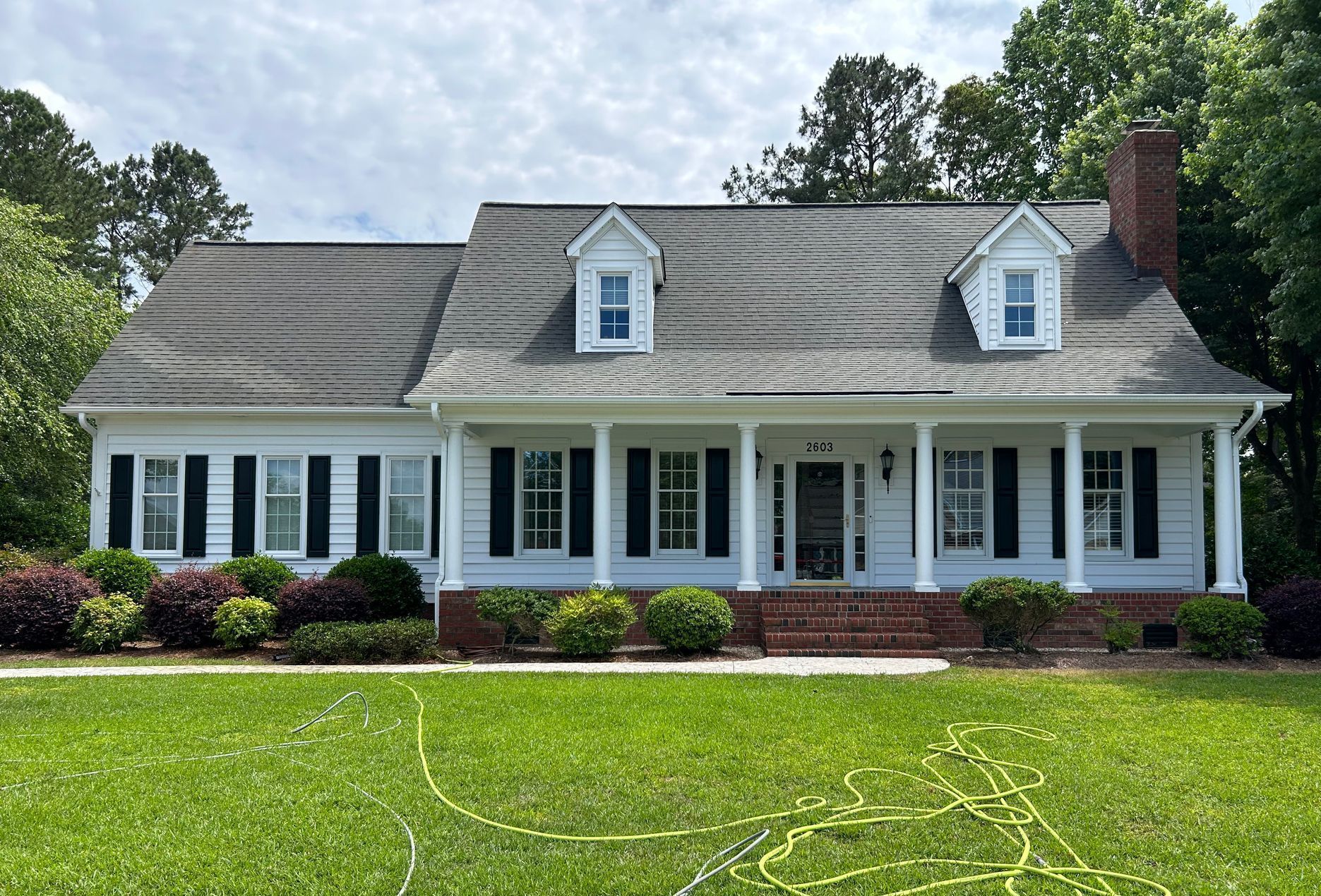 A roof with a drain on it is sitting on top of a brick driveway.