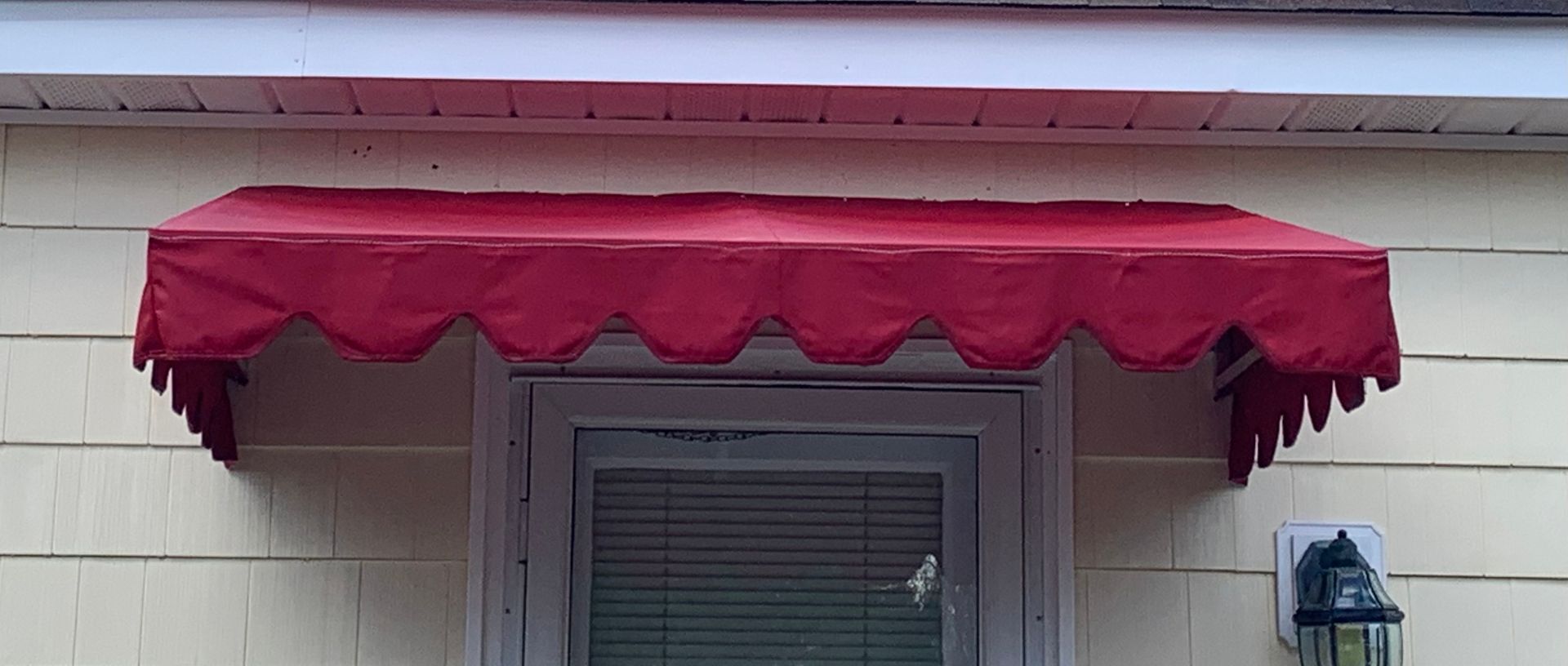 A brick building with a black awning over a door