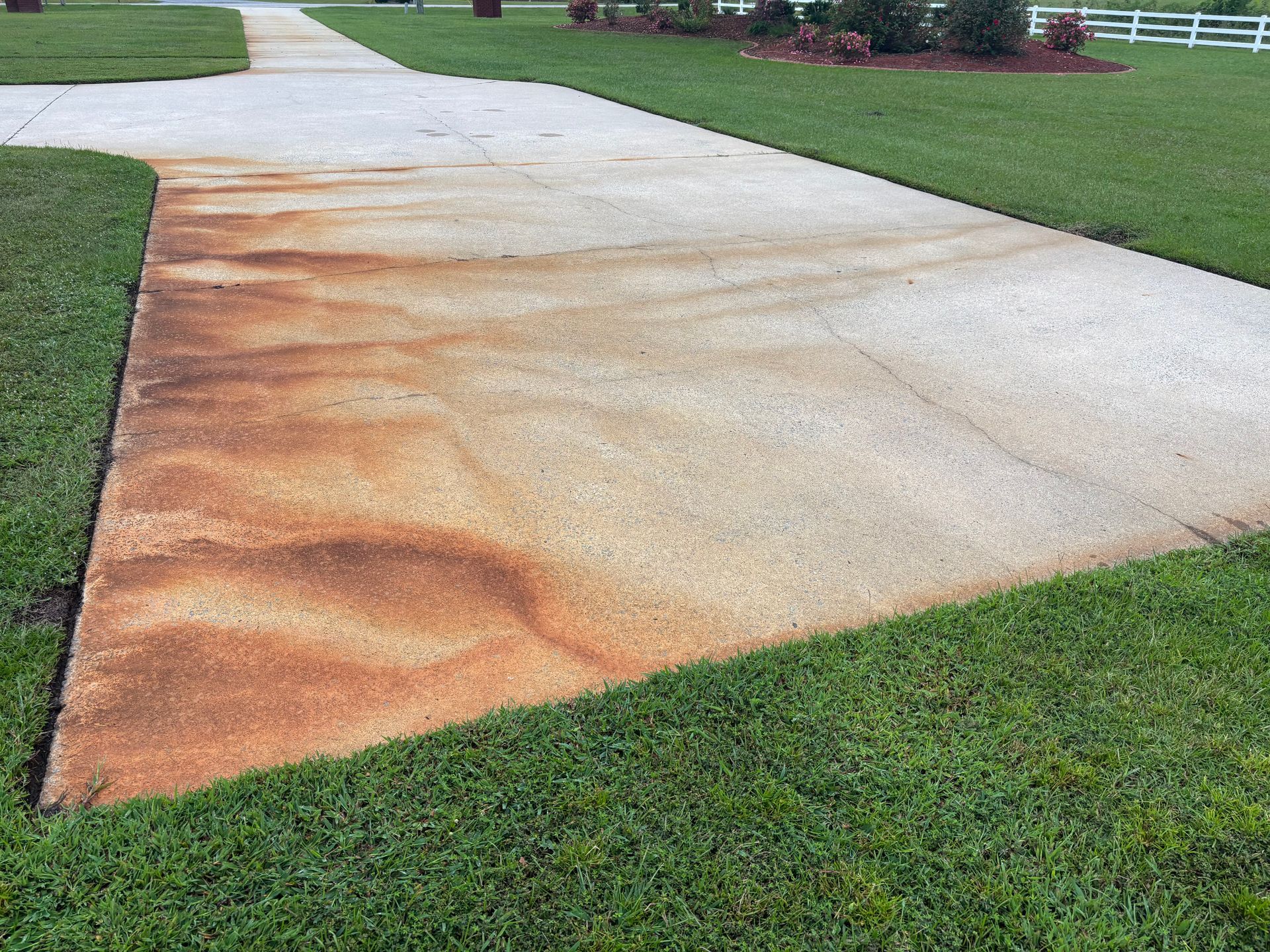 A dirty sidewalk in front of a house with a for sale sign.