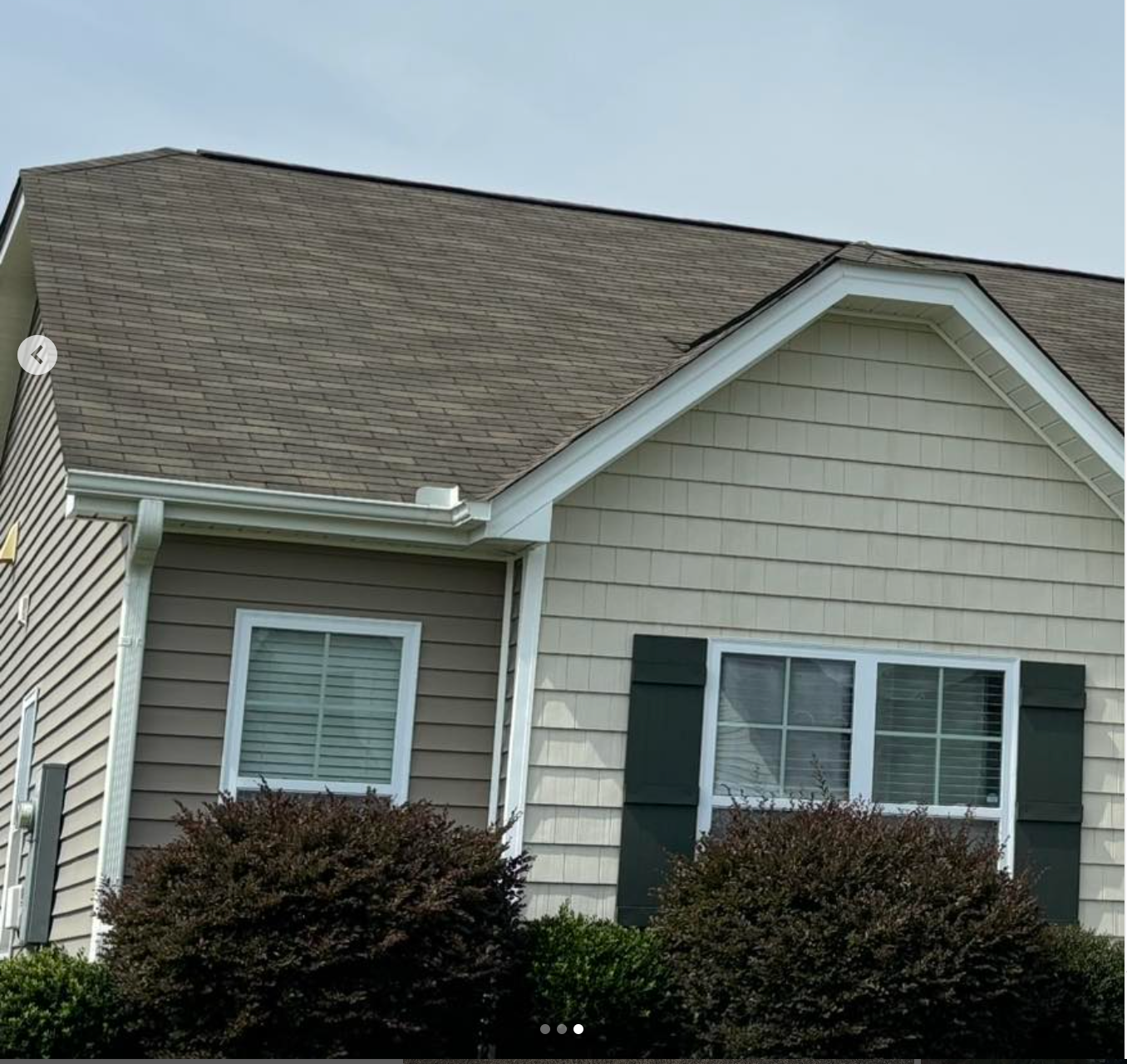 A house with a brown roof and black shutters