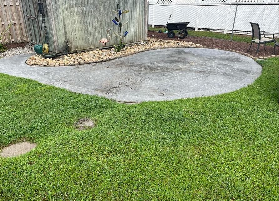 There is a wheelbarrow in the middle of the grass in the backyard.