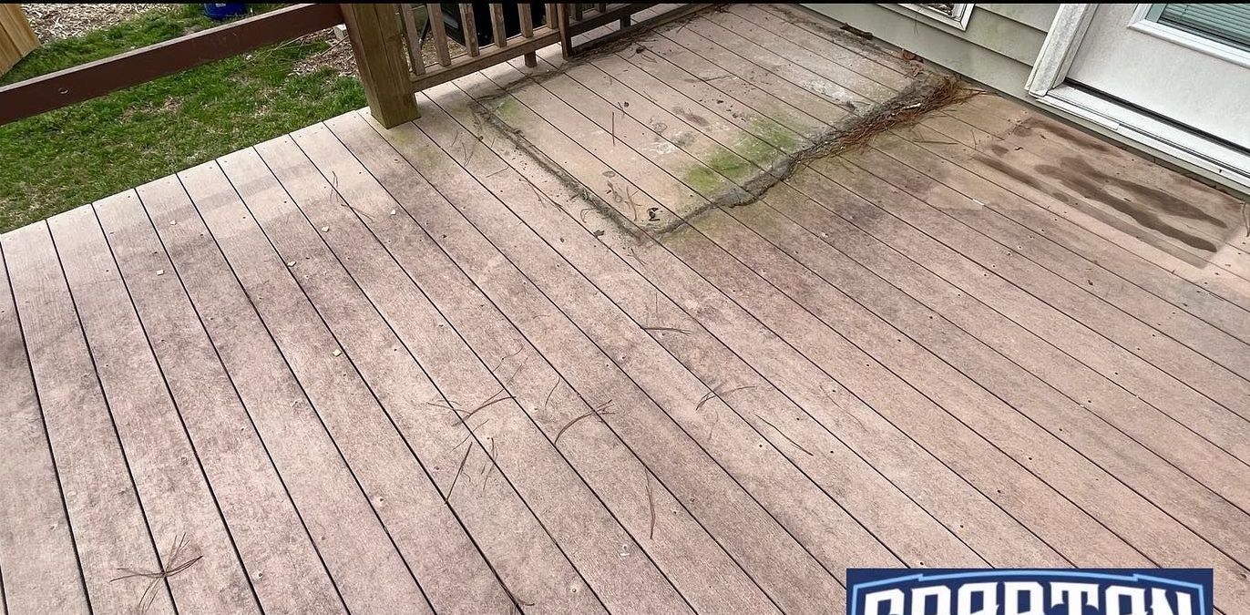 A wooden deck with a sliding glass door in the background