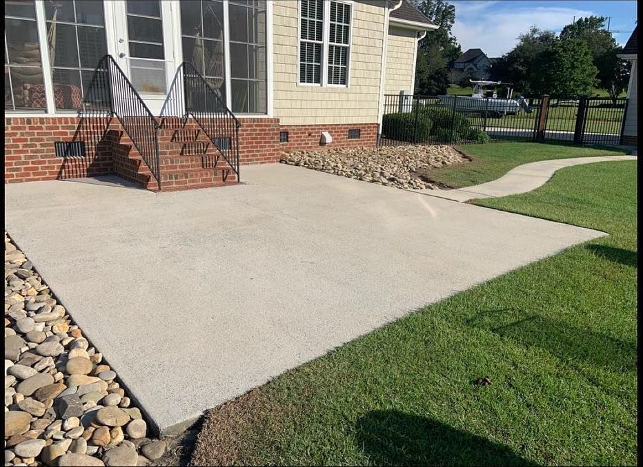 A brick house with a concrete driveway in front of it