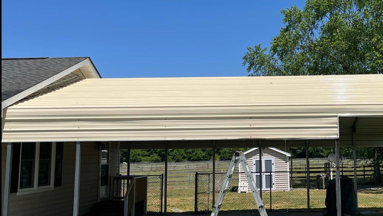 A carport is being built in front of a house.