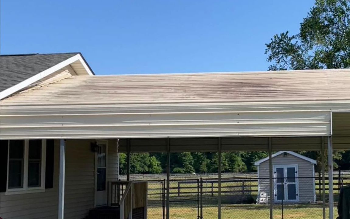 A house with a carport and a shed in the backyard.