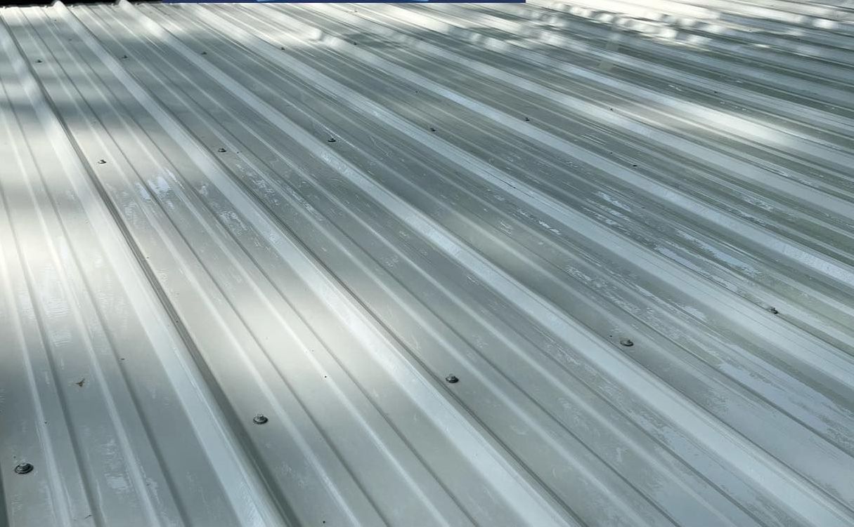 A close up of a metal roof with snow on it.