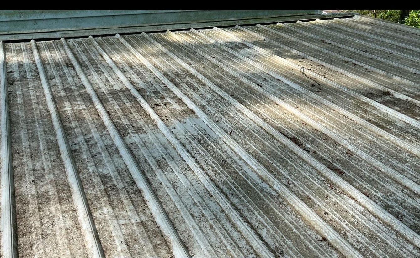 A close up of a dirty metal roof with a lot of holes in it.