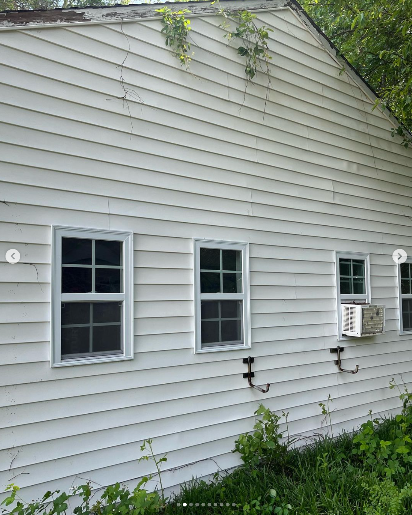 A white house with a window air conditioner on the side