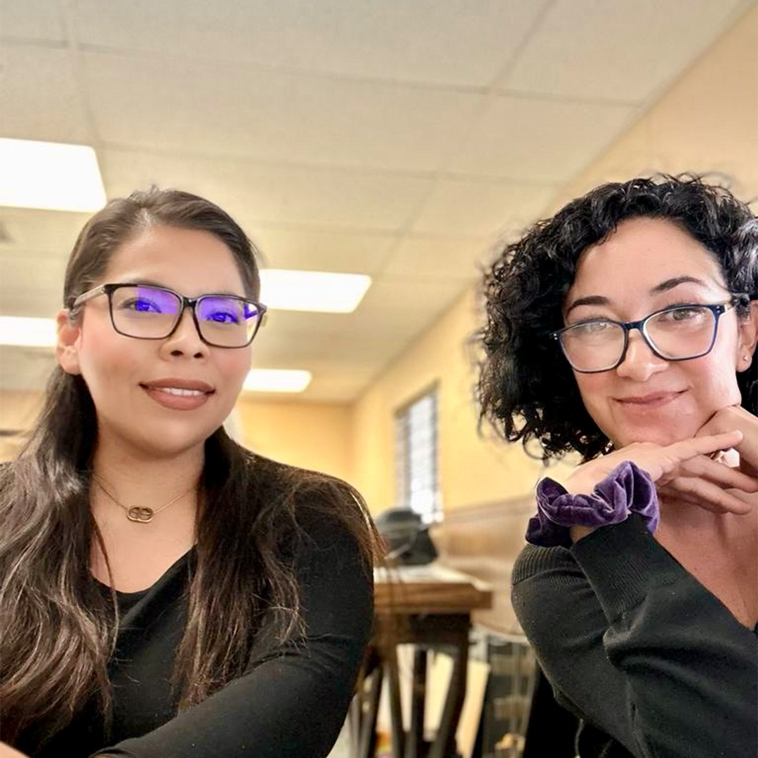 Two women wearing glasses are sitting next to each other