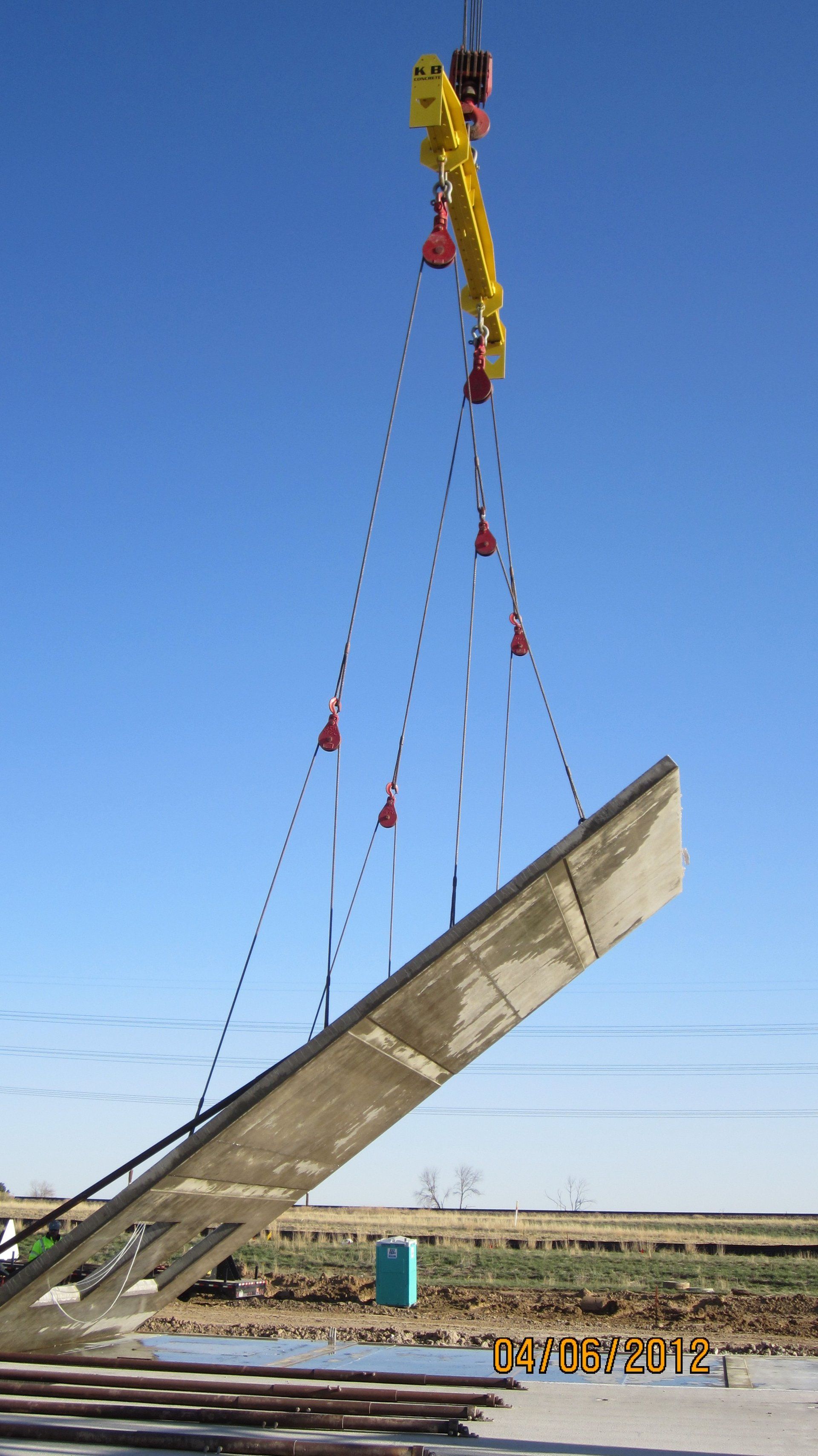 A large piece of concrete is being lifted by a crane