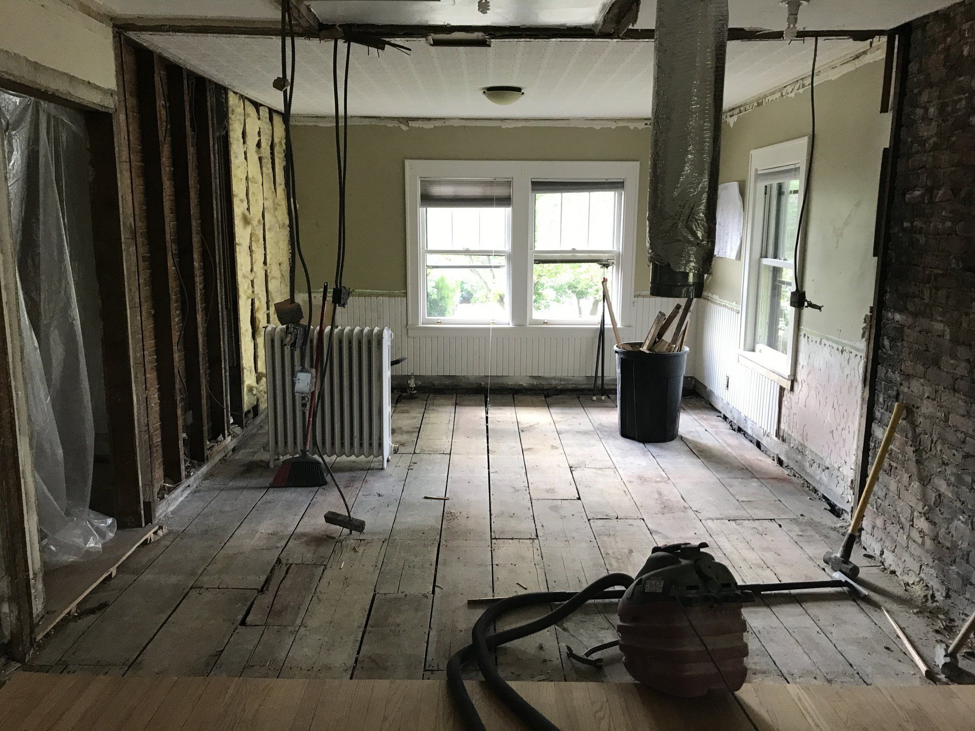 A room that is being remodeled with a vacuum cleaner on the floor