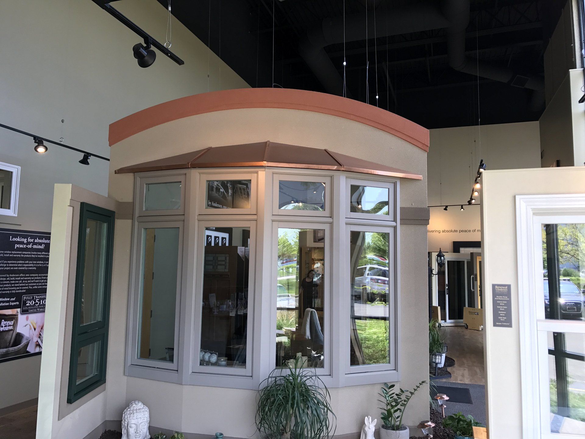 A showroom with a lot of windows and plants