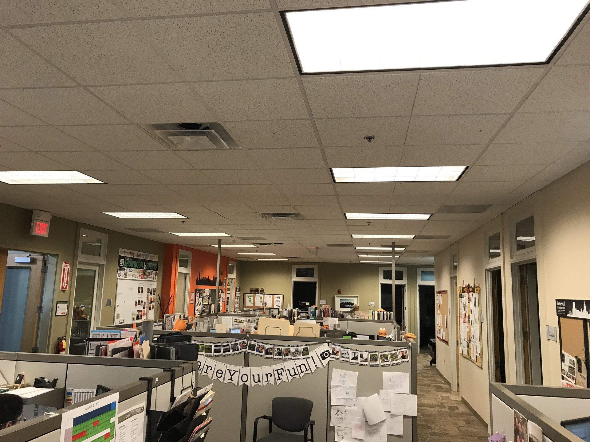 A large office with cubicles and a banner that says happy birthday