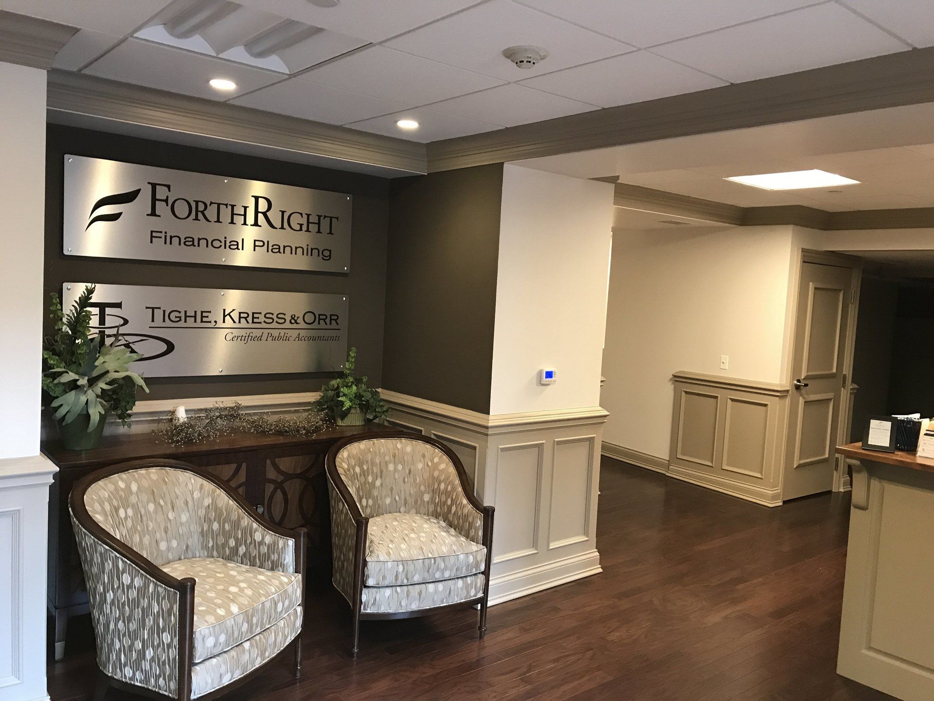 A waiting room with two chairs and a sign that says forthright financial planning