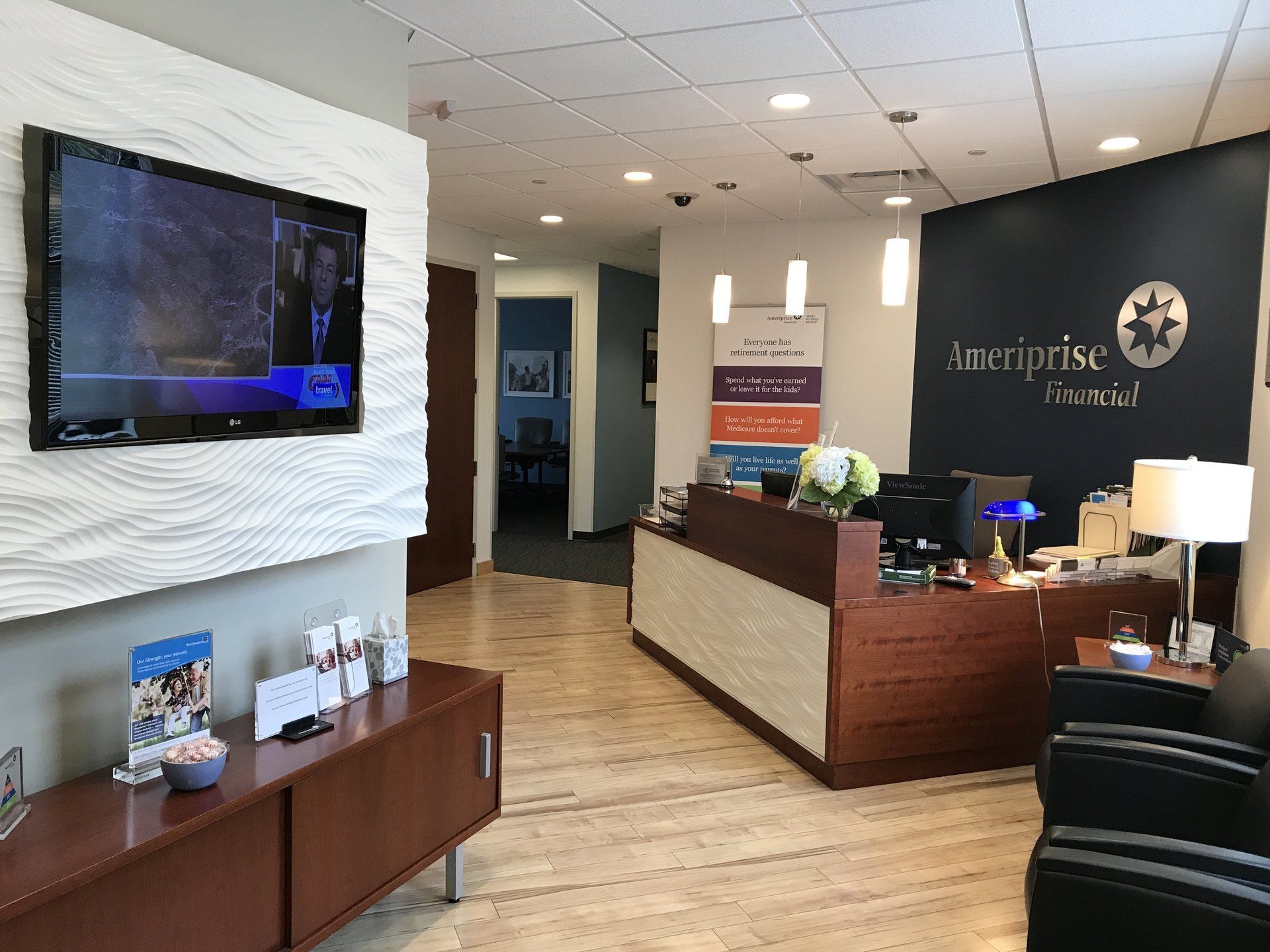 A waiting room with a large flat screen tv on the wall.
