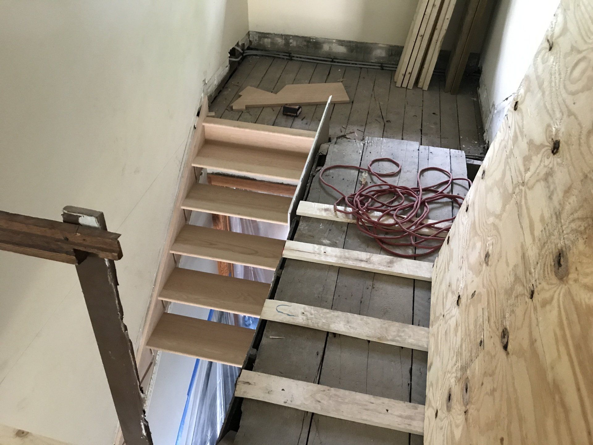A wooden staircase is being built in a room.