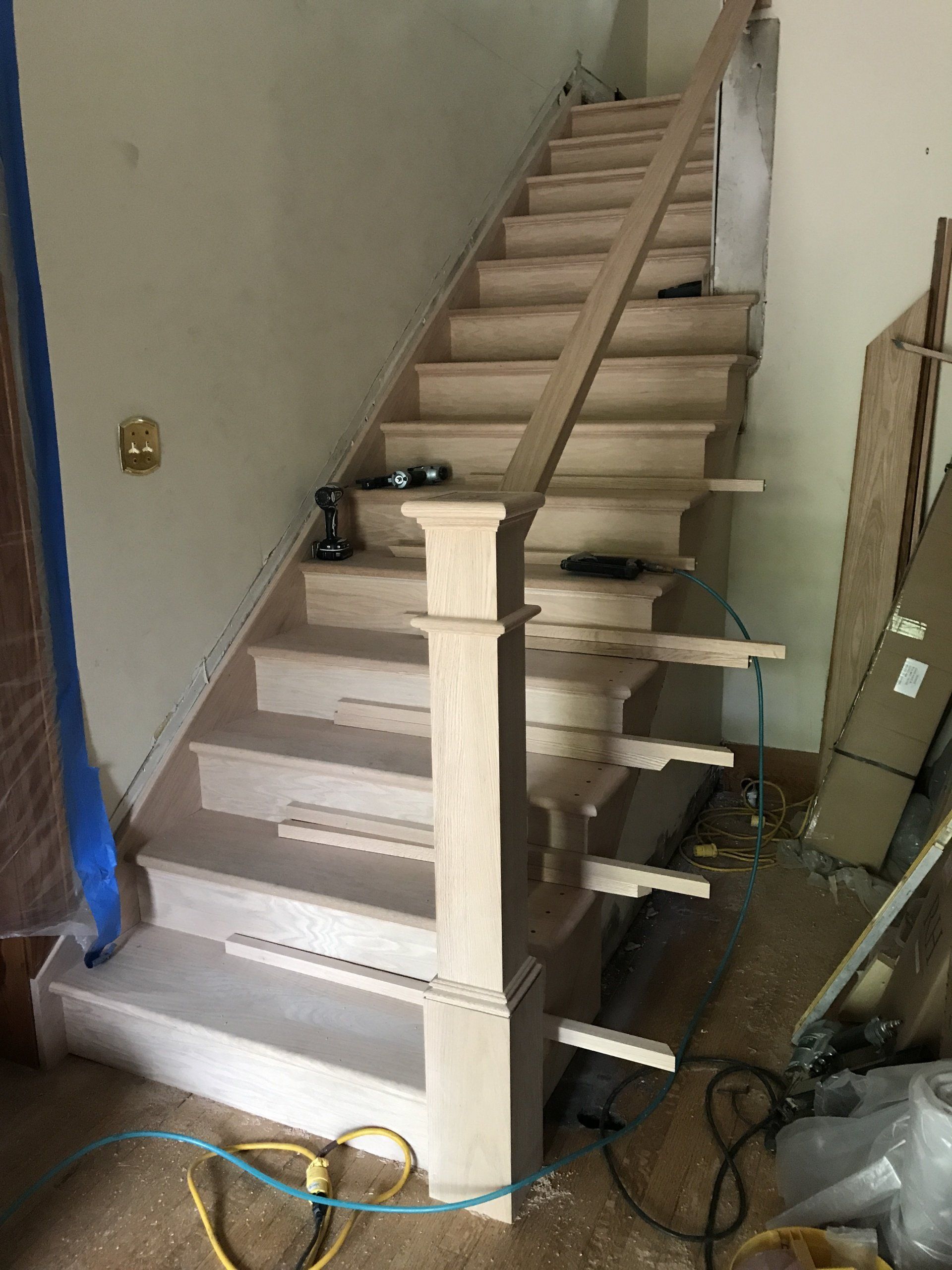A wooden staircase is being built in a room.