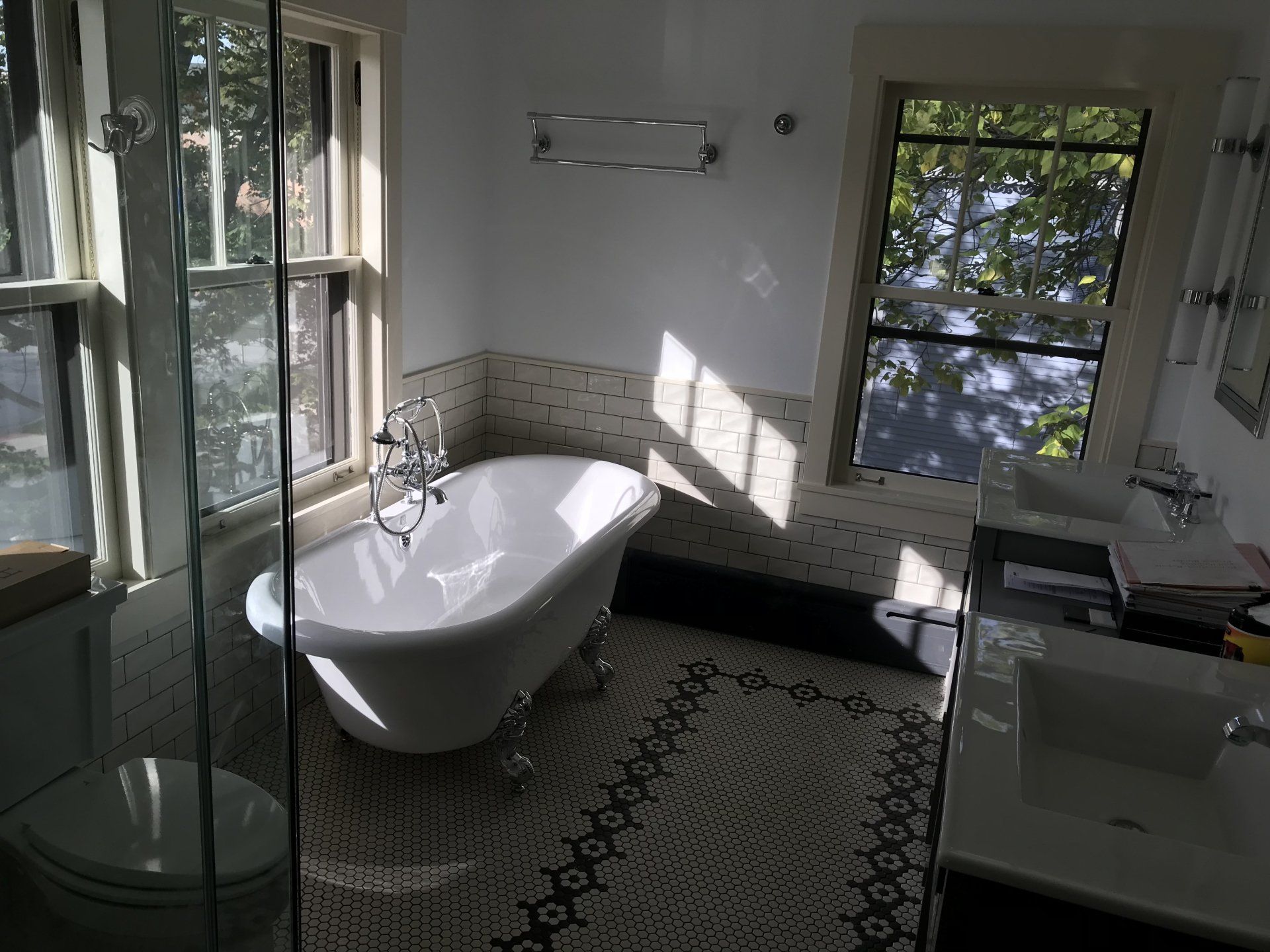 A bathroom with a tub , sink , toilet and window.