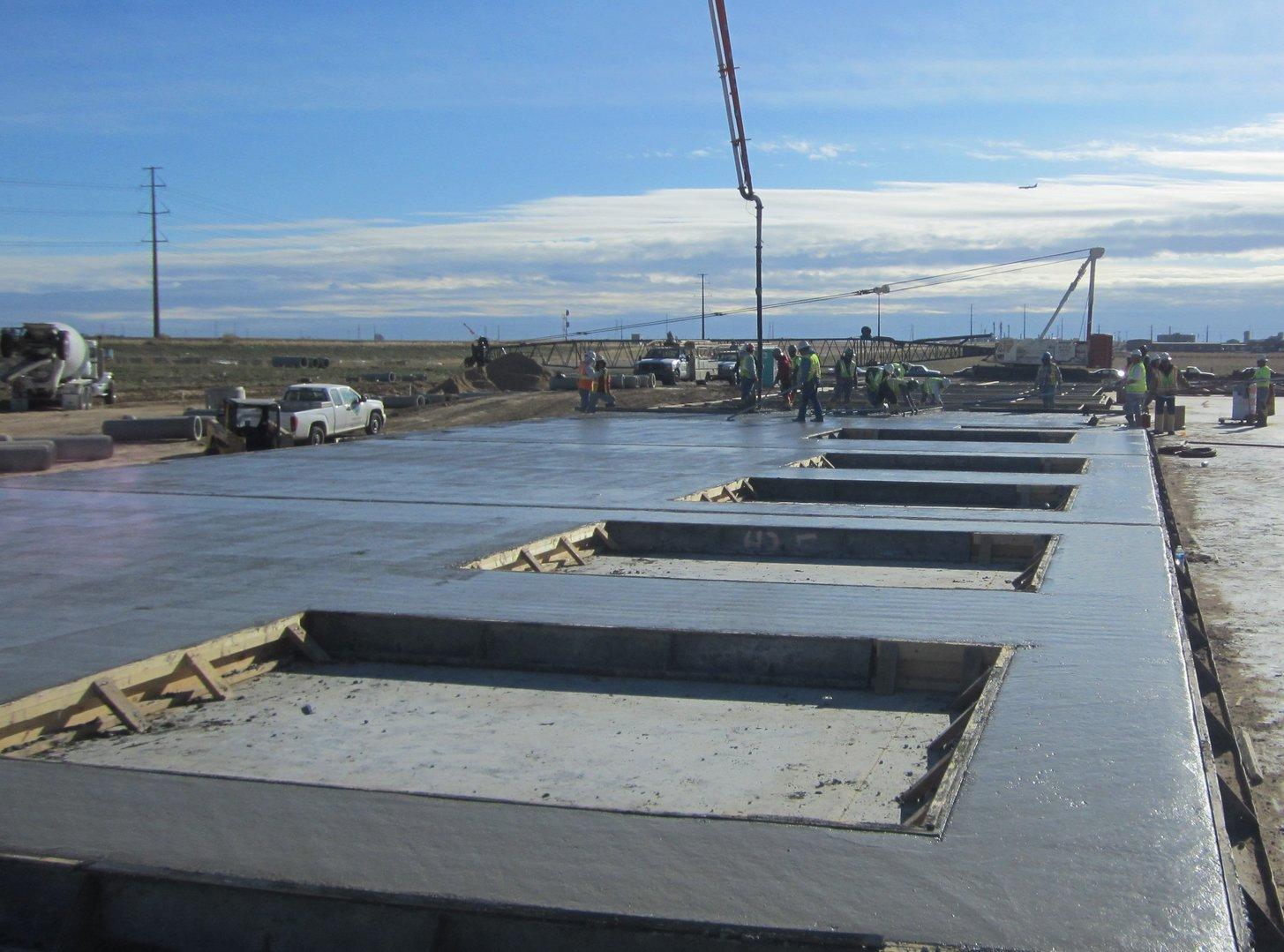 A group of construction workers are working on a concrete floor